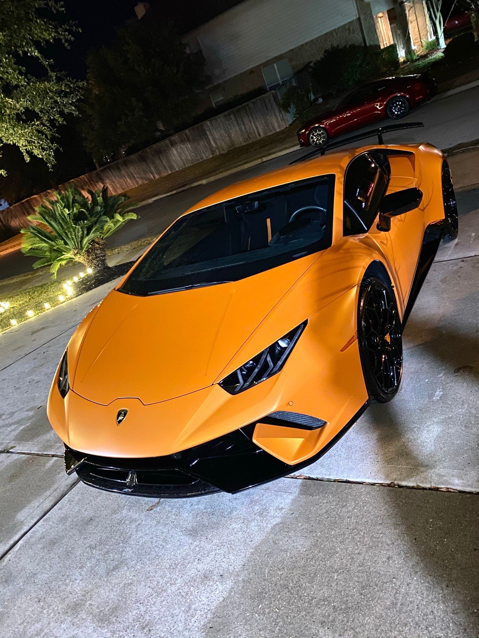 Blue Lamborghini car hood with water droplets, showing the emblem.