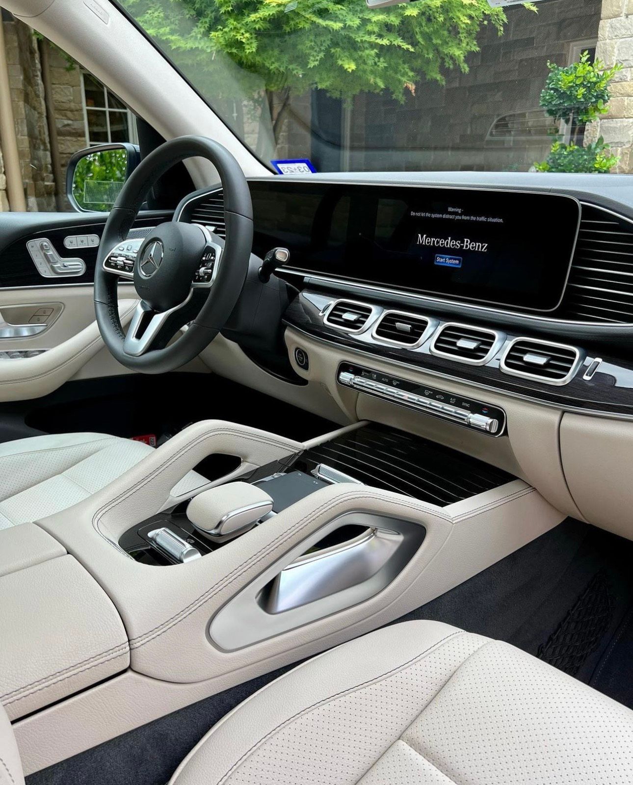 Beige and black Mercedes-Benz interior, leather seats, steering wheel, console, dashboard, sunlight.