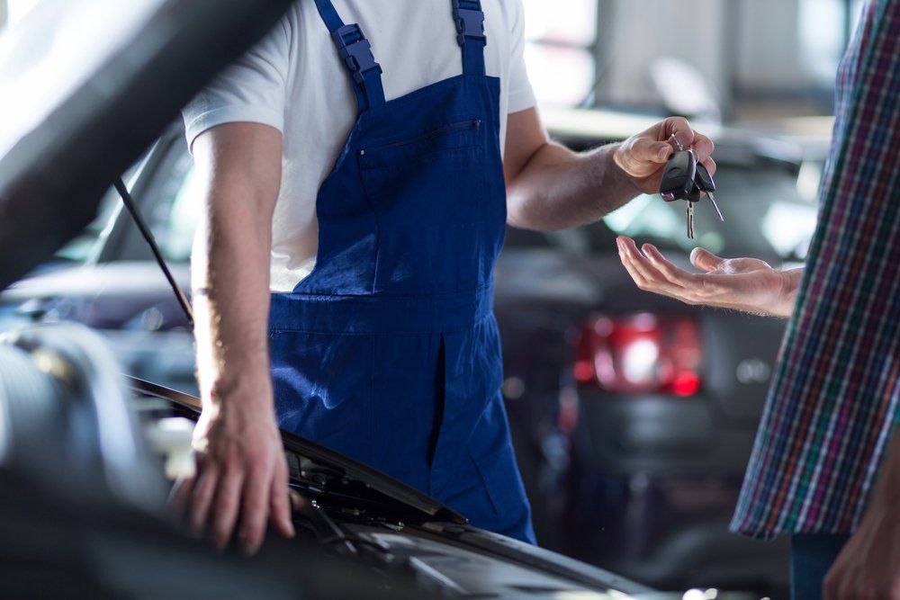 Auto mechanic's hands giving a car keys — Auto Electrician Near Me in Acacia Hills NT