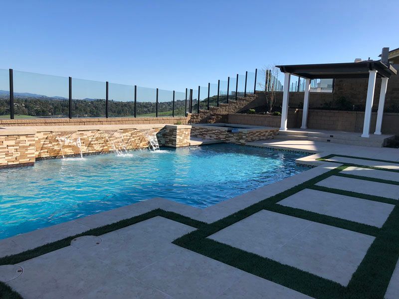 A large swimming pool with a glass fence around it