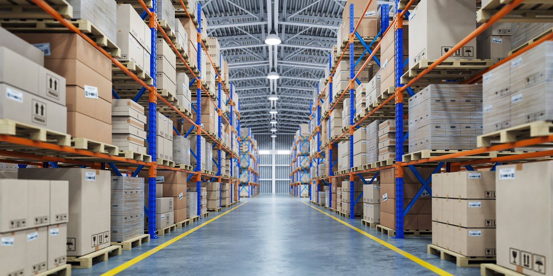 Aisle in a large warehouse with tall shelves of stacked boxes and pallet racks on both sides.