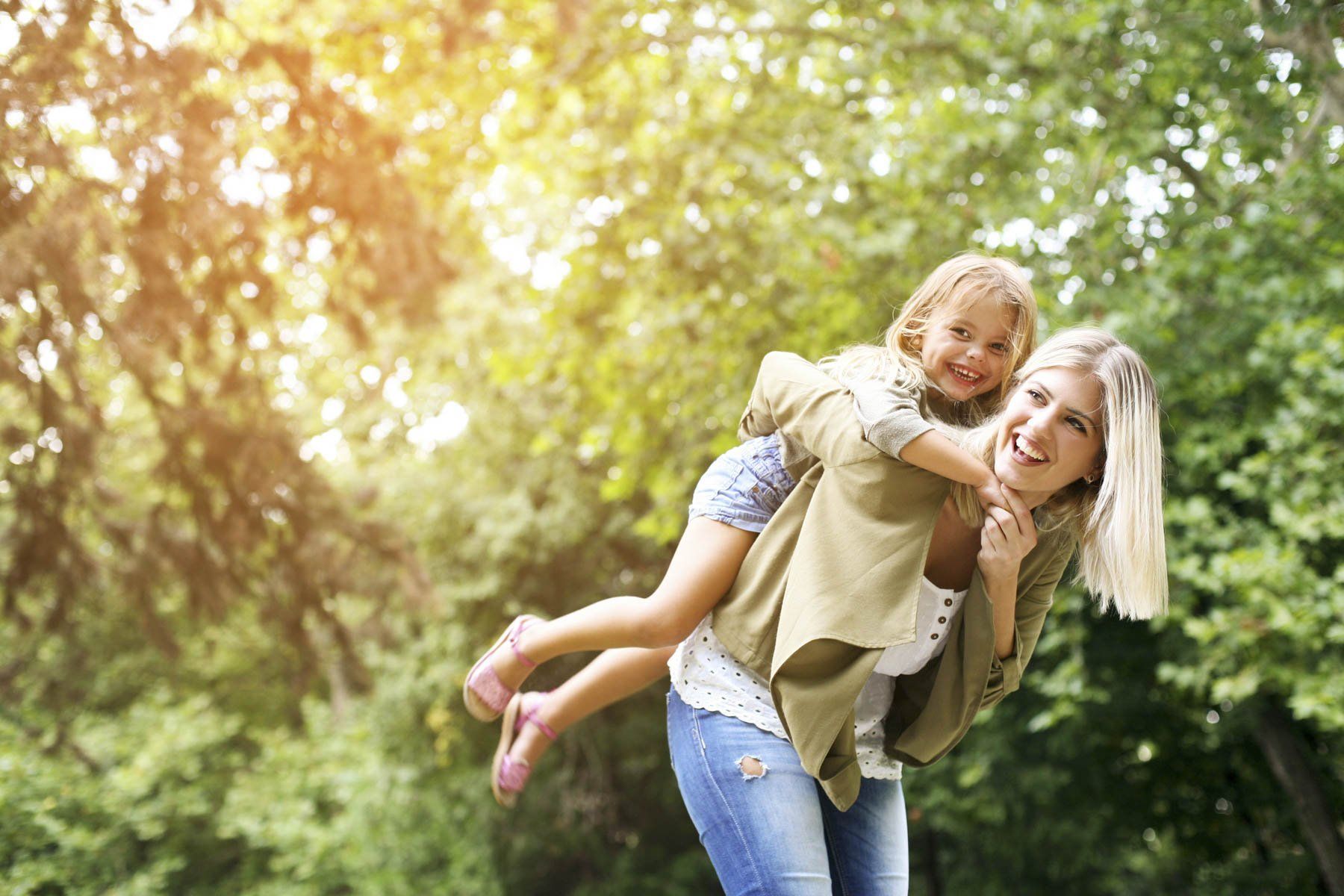 Little girl on a piggy back ride with her mother.