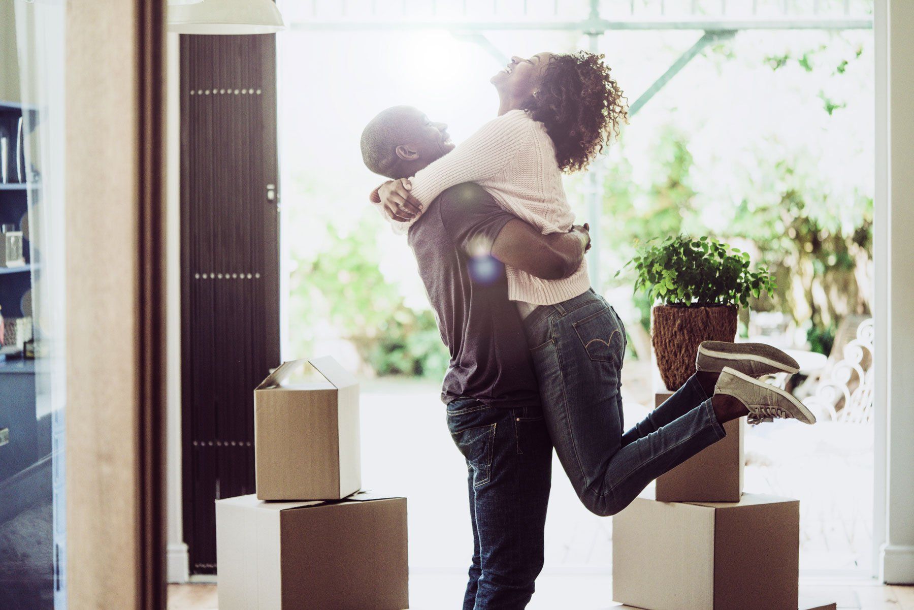 Happy man lifting woman in new house