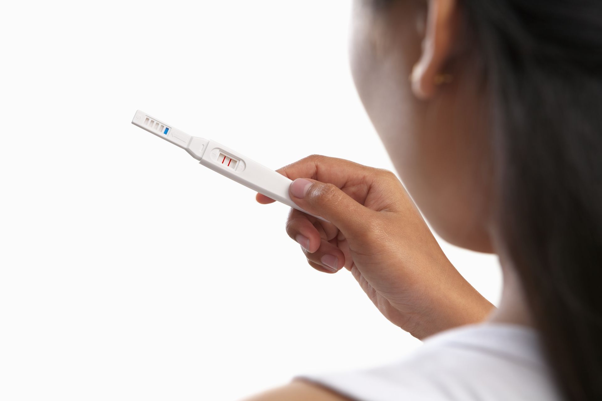 Woman holding positive pregnancy test.