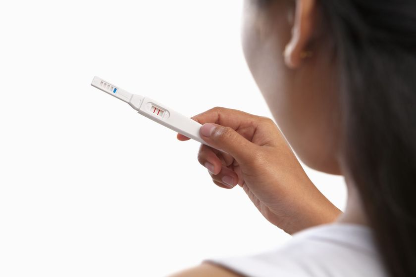 Woman holding positive pregnancy test.