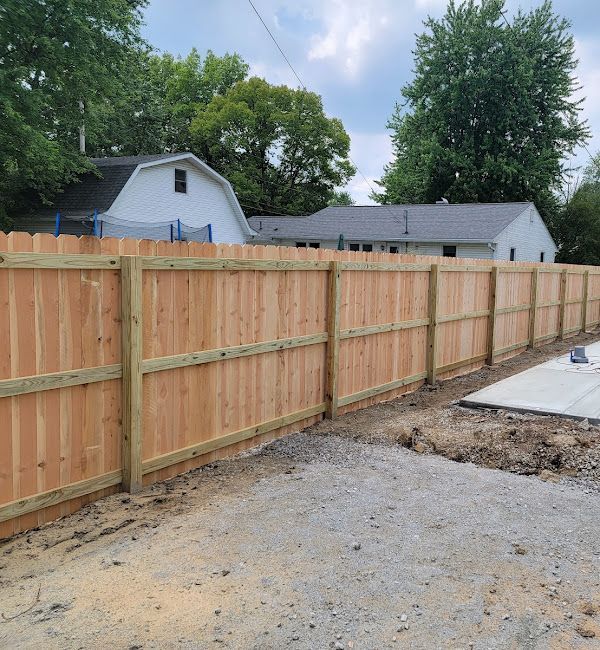 A wooden fence is being built in front of a house.