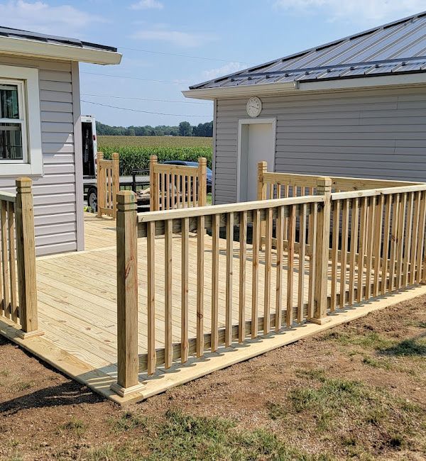 A wooden deck with a fence in front of a house