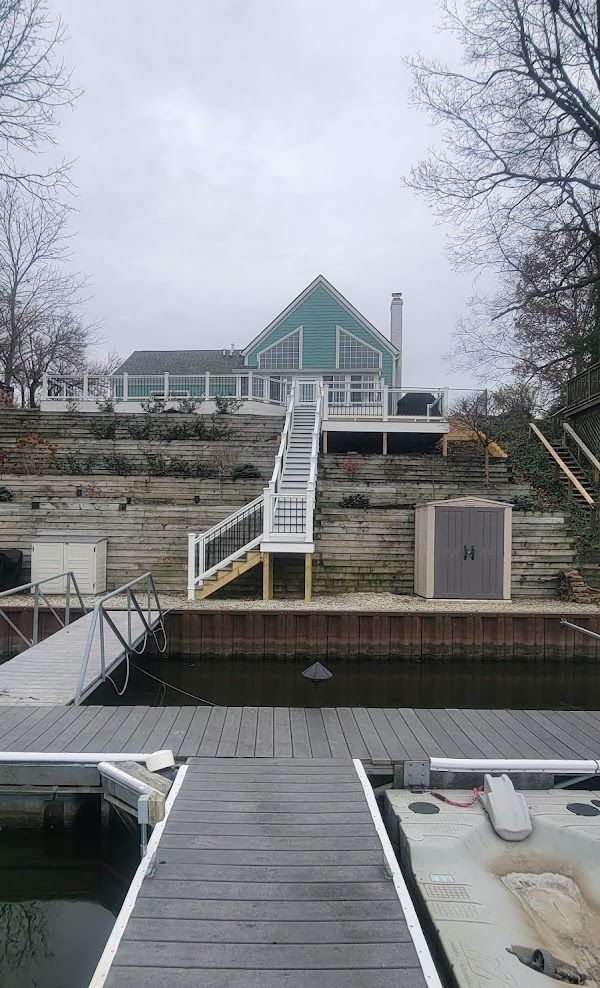 A boat is docked at a dock in front of a house.