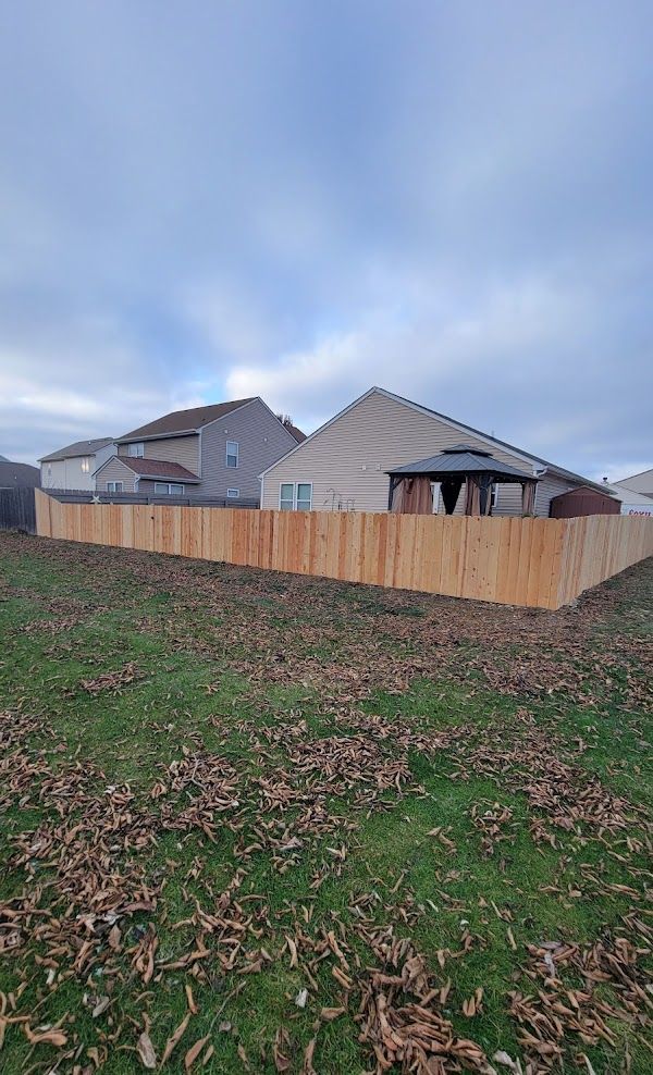 There is a wooden fence in the backyard of a house.