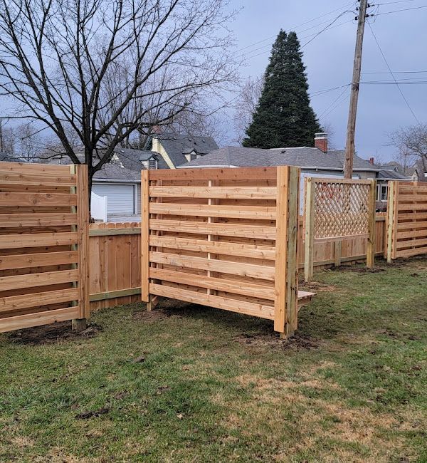 A wooden fence is sitting in the middle of a grassy field.