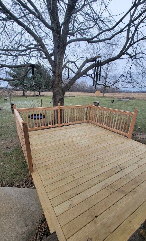 A wooden deck with a tree in the background.