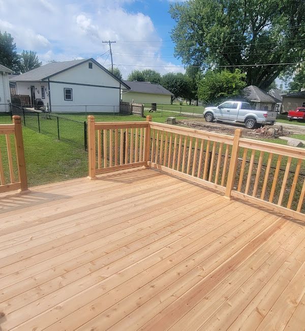 A wooden deck with a railing and a house in the background.