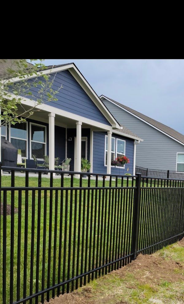 A blue house with a black fence in front of it.