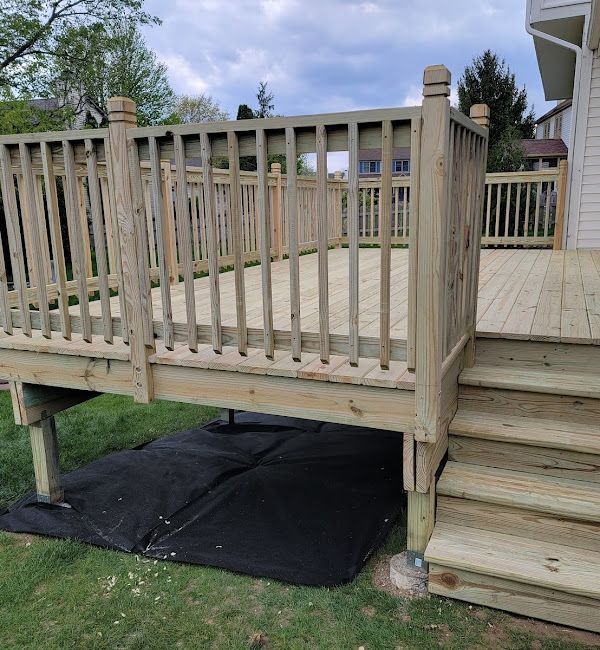 A wooden deck with stairs and a railing in front of a house.