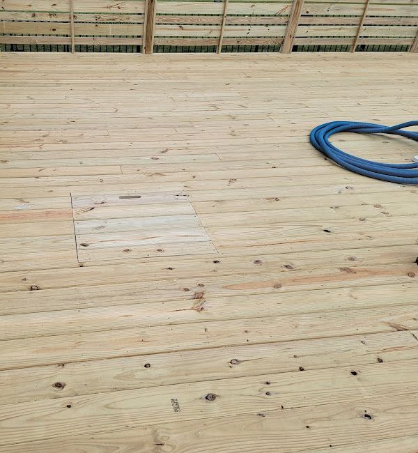 A wooden deck with a blue hose on it.