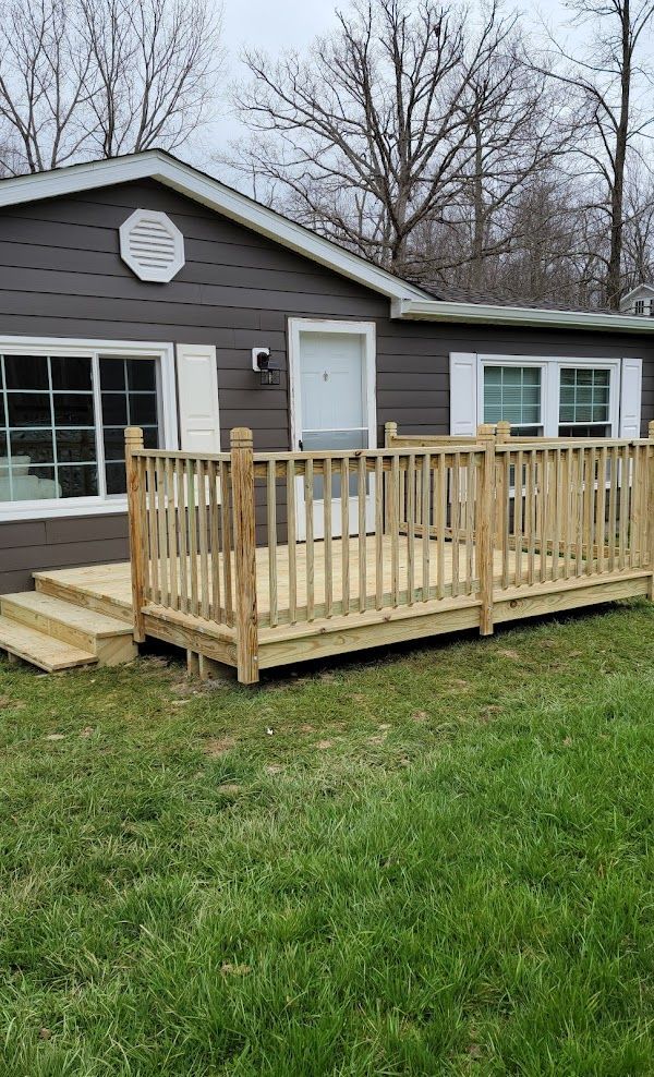 A small house with a wooden deck in front of it.