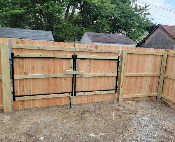 A wooden fence with a gate attached to it.