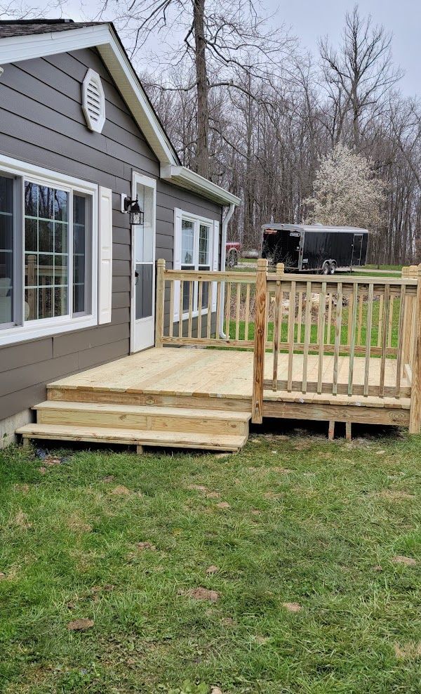 A house with a wooden deck and stairs in front of it.