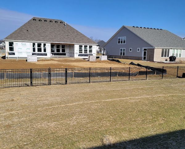 A couple of houses with a fence in front of them
