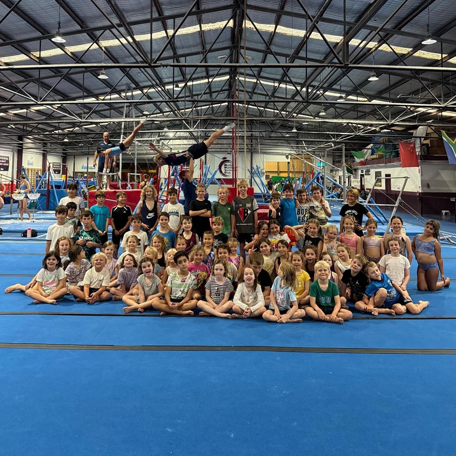 A group of children are posing for a picture in a gym.