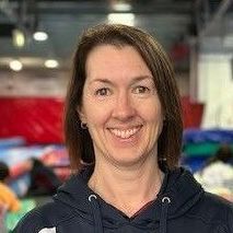 A woman in a blue hoodie is smiling for the camera.