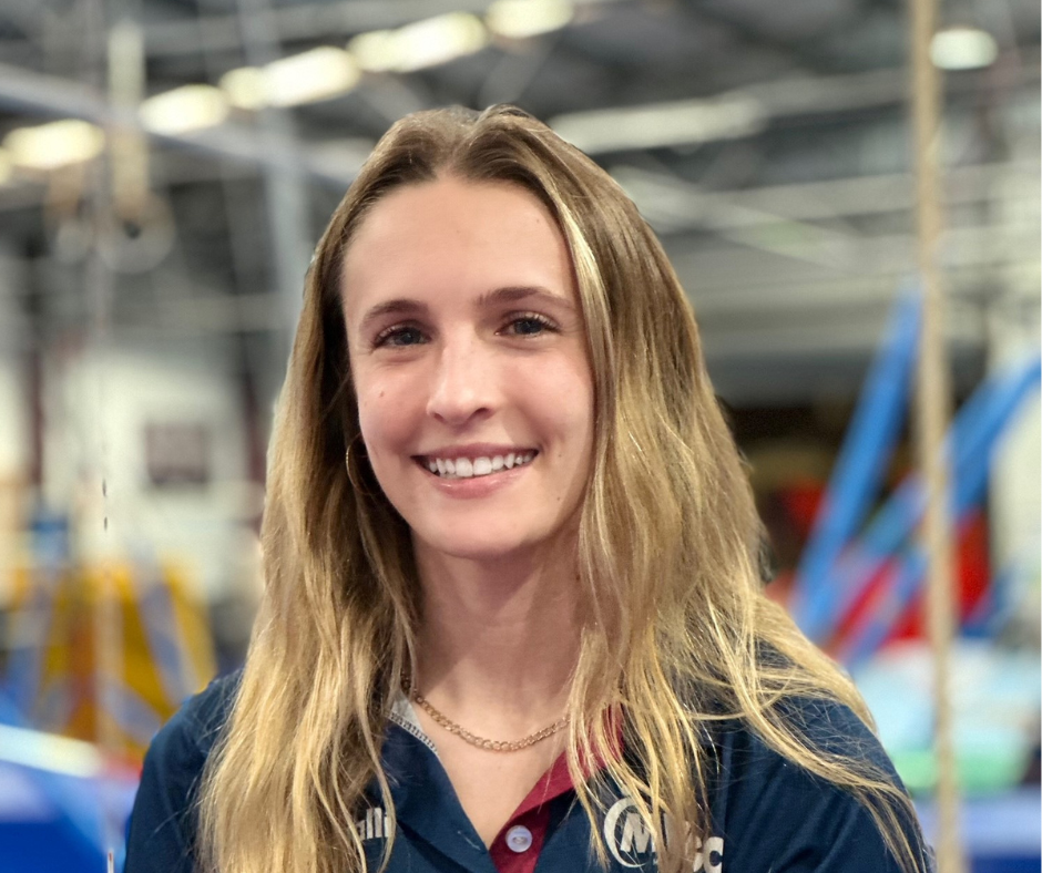 A young woman is smiling for the camera in a gym.