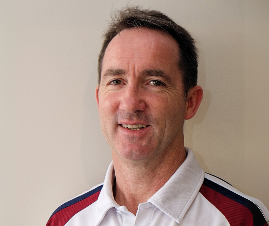 A man wearing a white and maroon shirt is smiling for the camera.