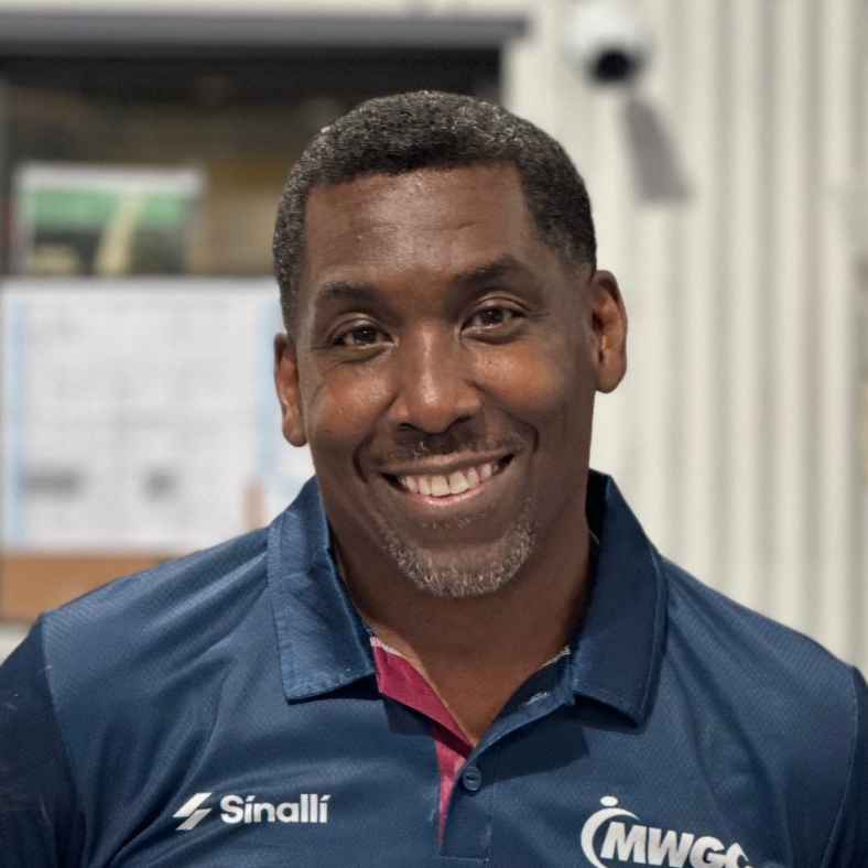 A man wearing a sinalli shirt is smiling for the camera
