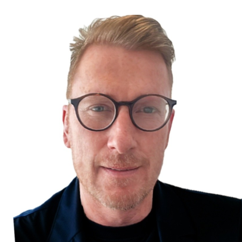 A man with glasses and a beard is smiling for the camera