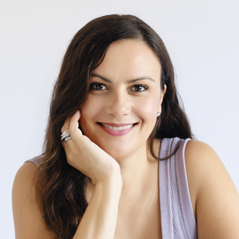A woman is smiling with her hand on her face