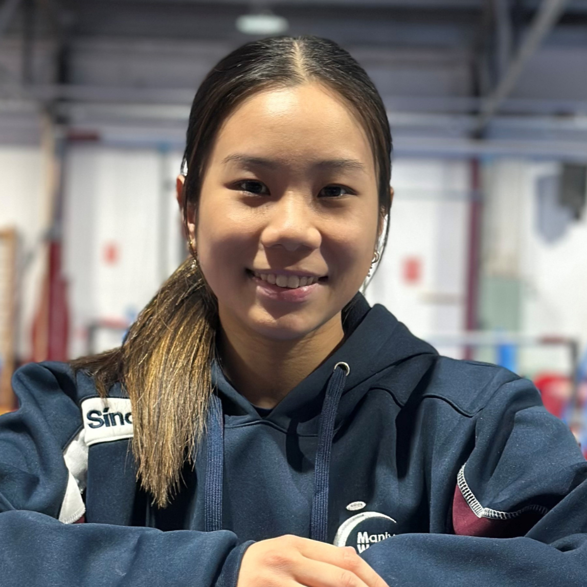A woman wearing a blue shirt that says sinalli on it
