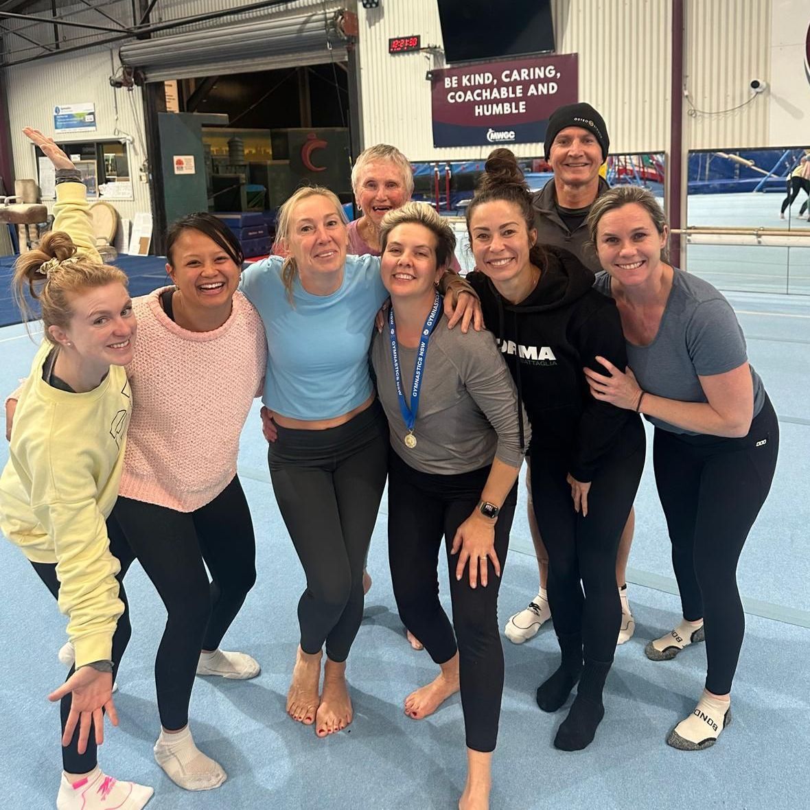 A group of women are posing for a picture in a gym