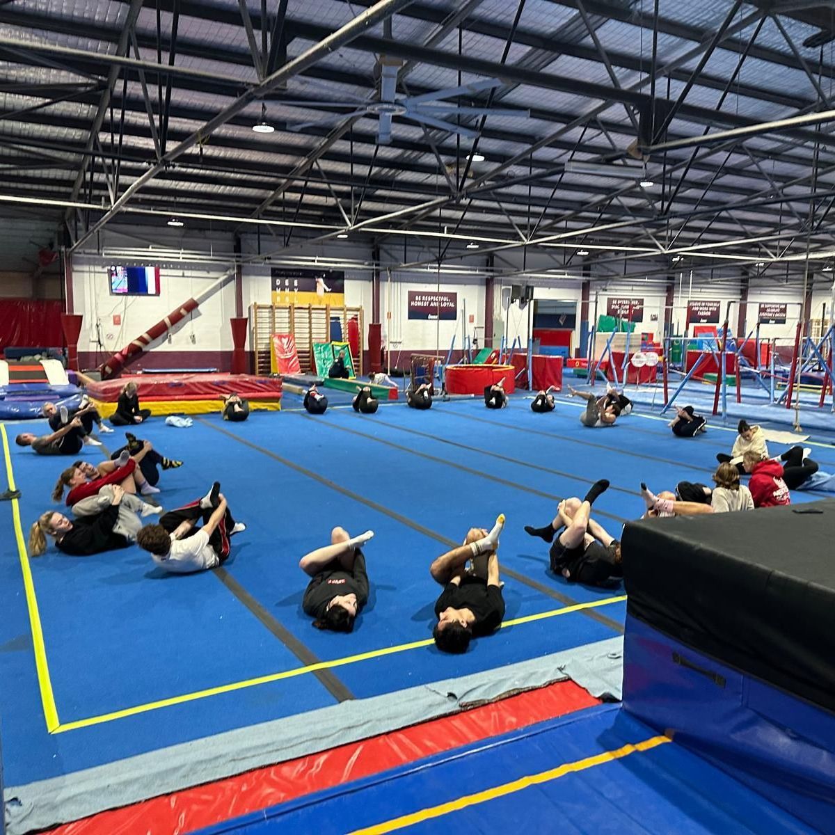 A group of people are doing exercises on a gym floor