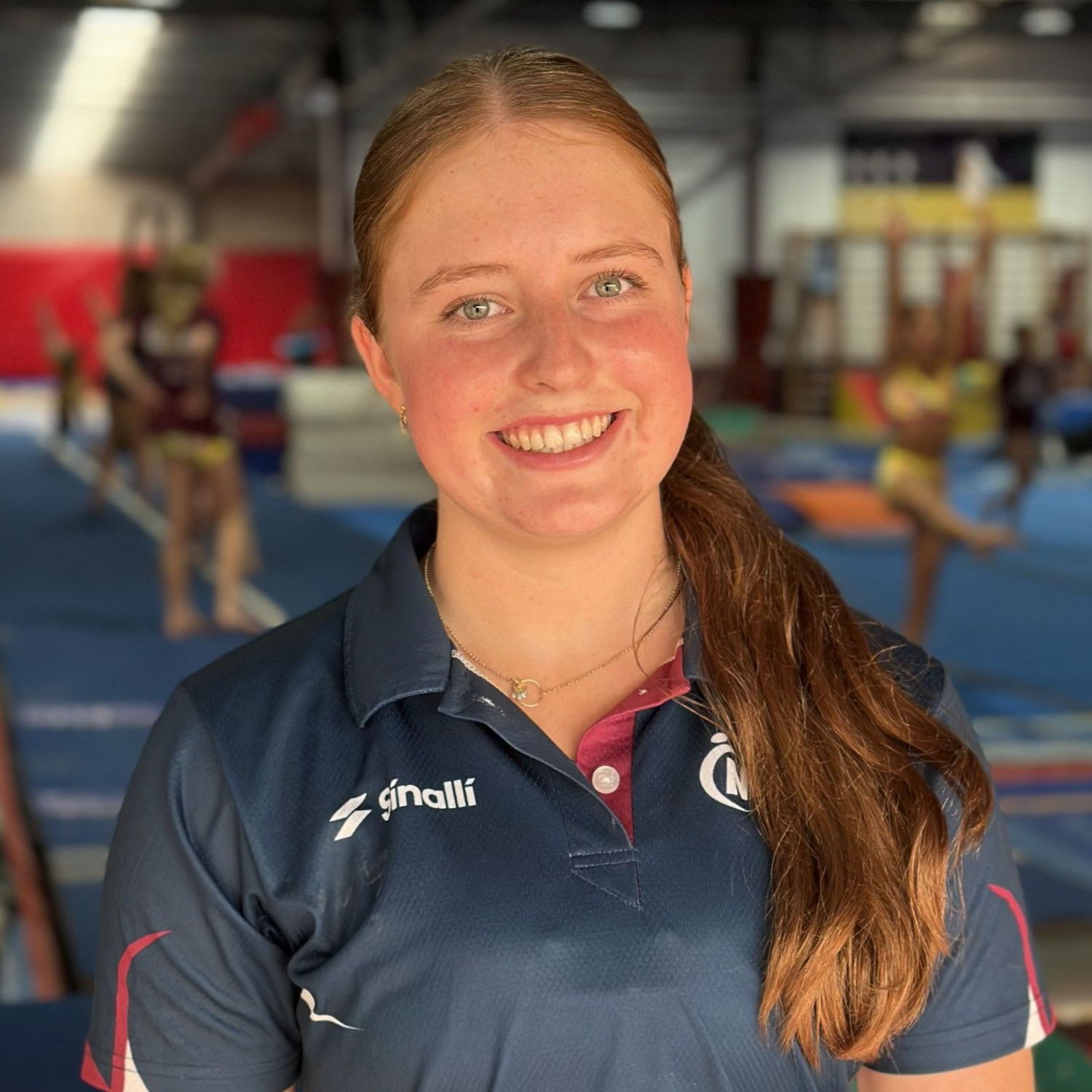 A man in a blue shirt is holding gymnastic rings over his head