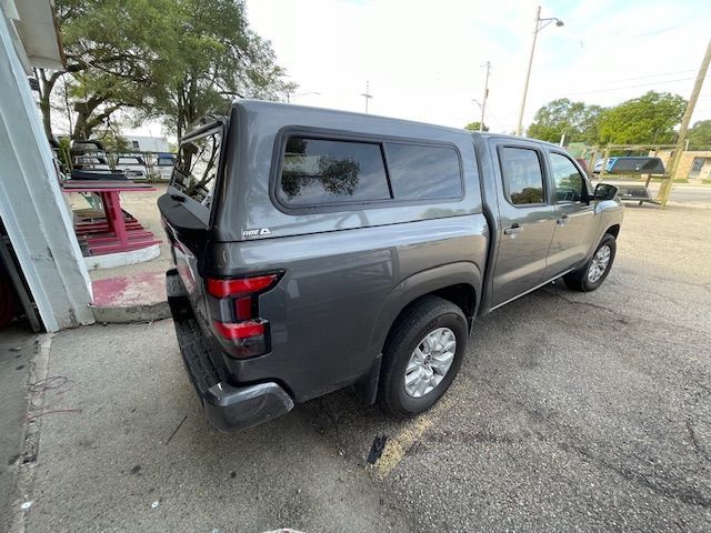 Gray pickup truck with a camper shell parked on asphalt.