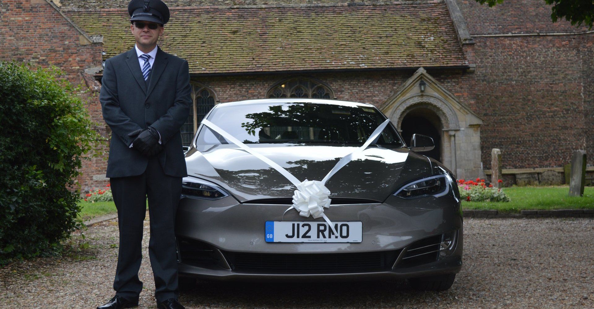 A chauffeur beside a wedding car
