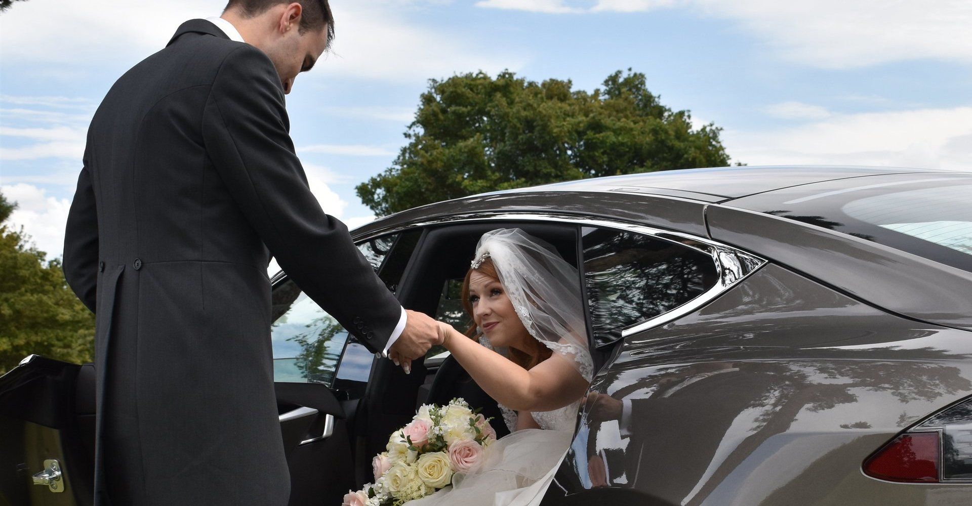 newly wed coming out of the wedding car