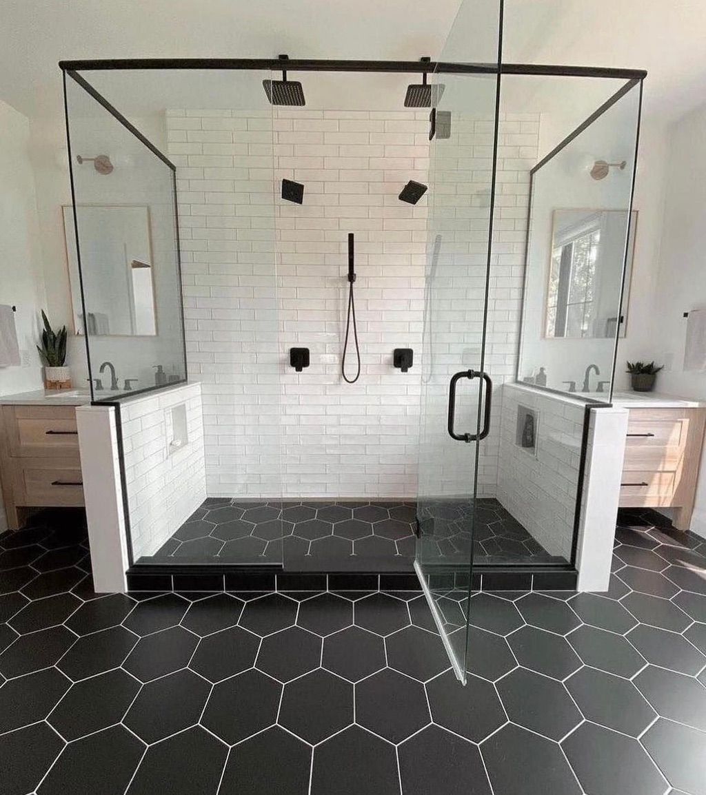 Modern bathroom with a large glass shower, black fixtures, and hexagon tile floors.