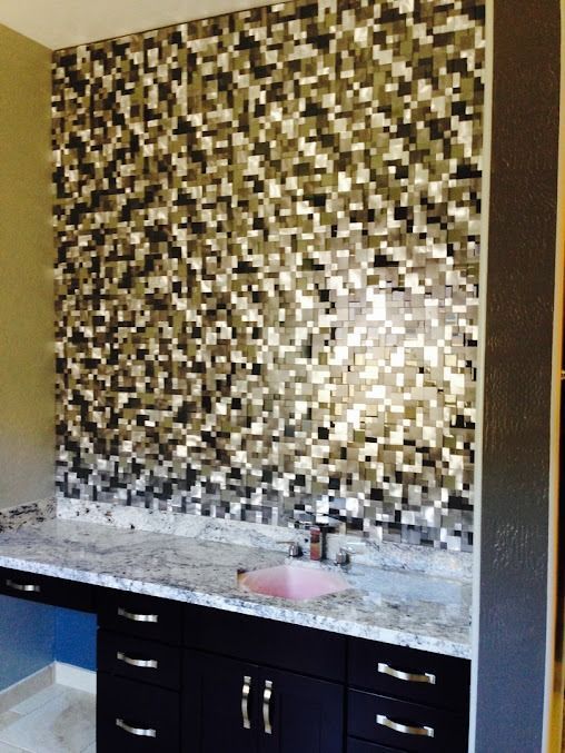 Vanity with mosaic tile wall, granite countertop, black cabinets, and pink sink.
