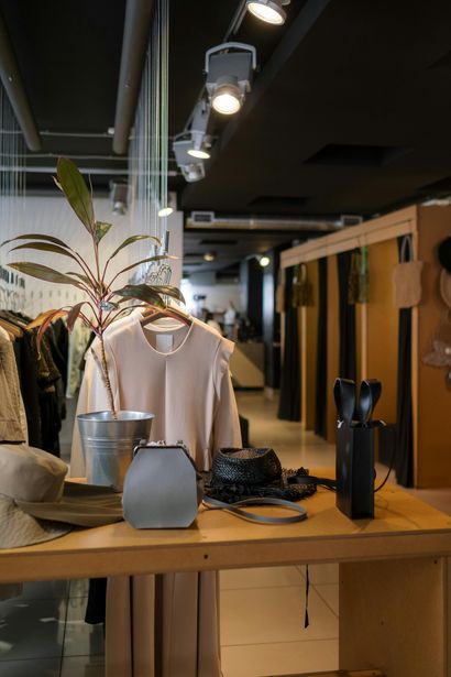 A table in a store with clothes and a plant on it.