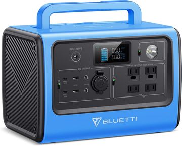 Persona sostiene una máquina de niebla gris, produciendo humo en un estudio con equipo.