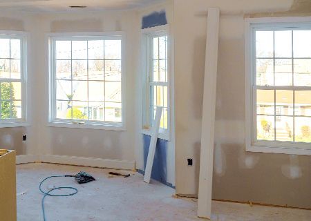 A room with a lot of windows is being remodeled.