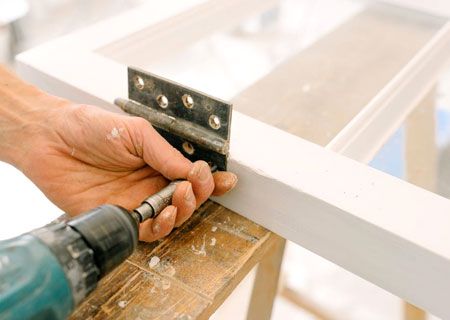 A person is using a drill to drill a hole in a piece of wood.