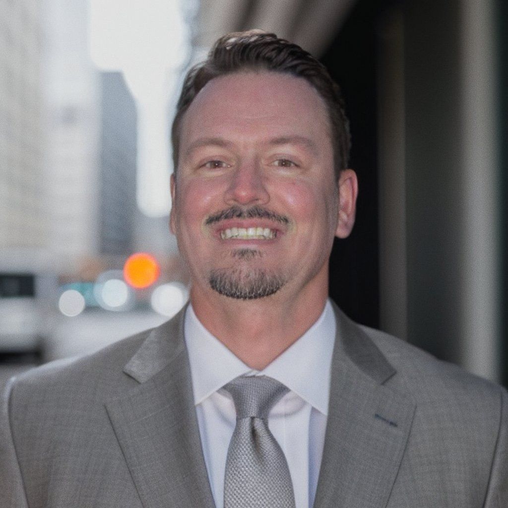 A man in a suit and tie is smiling for the camera.