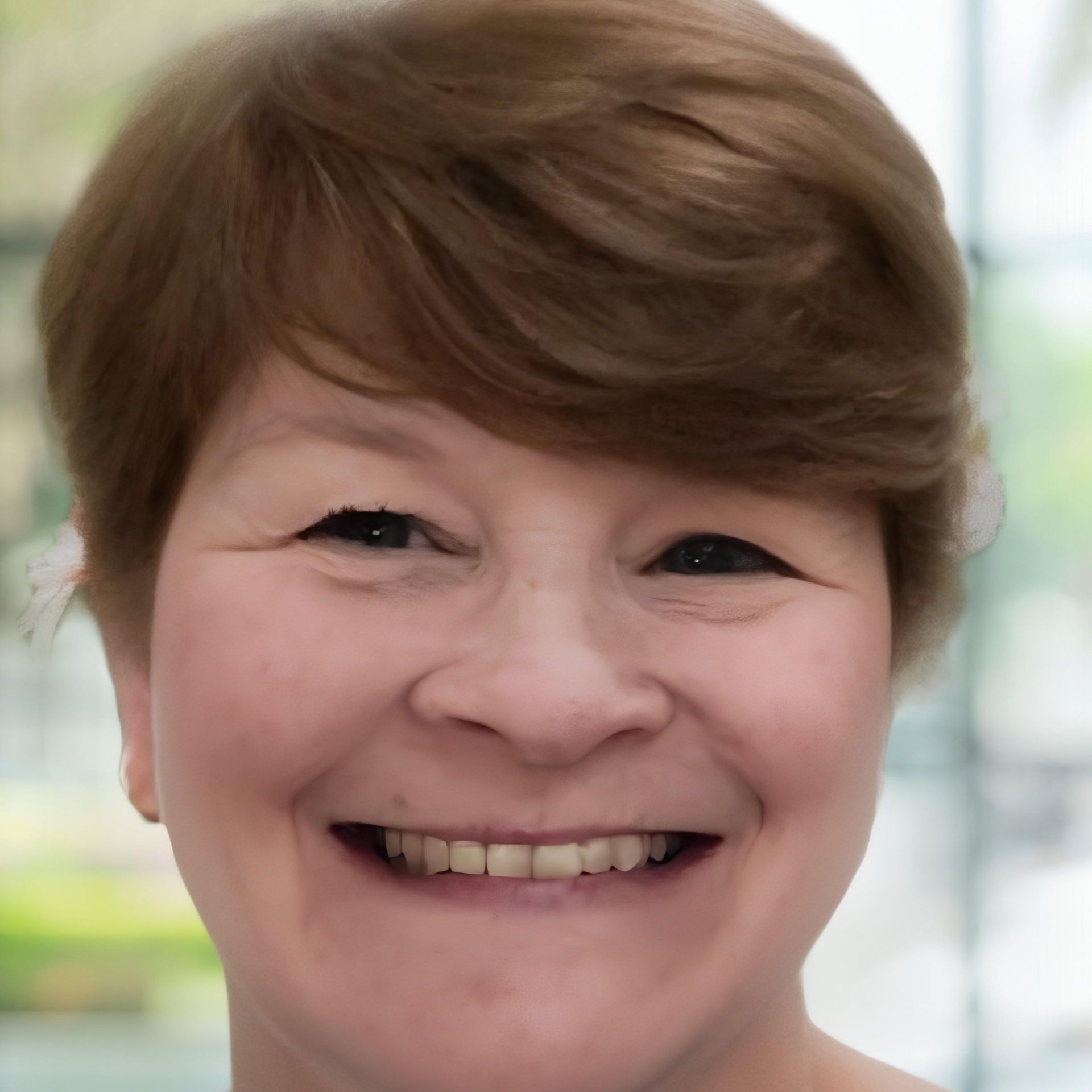 A woman with short brown hair is smiling for the camera