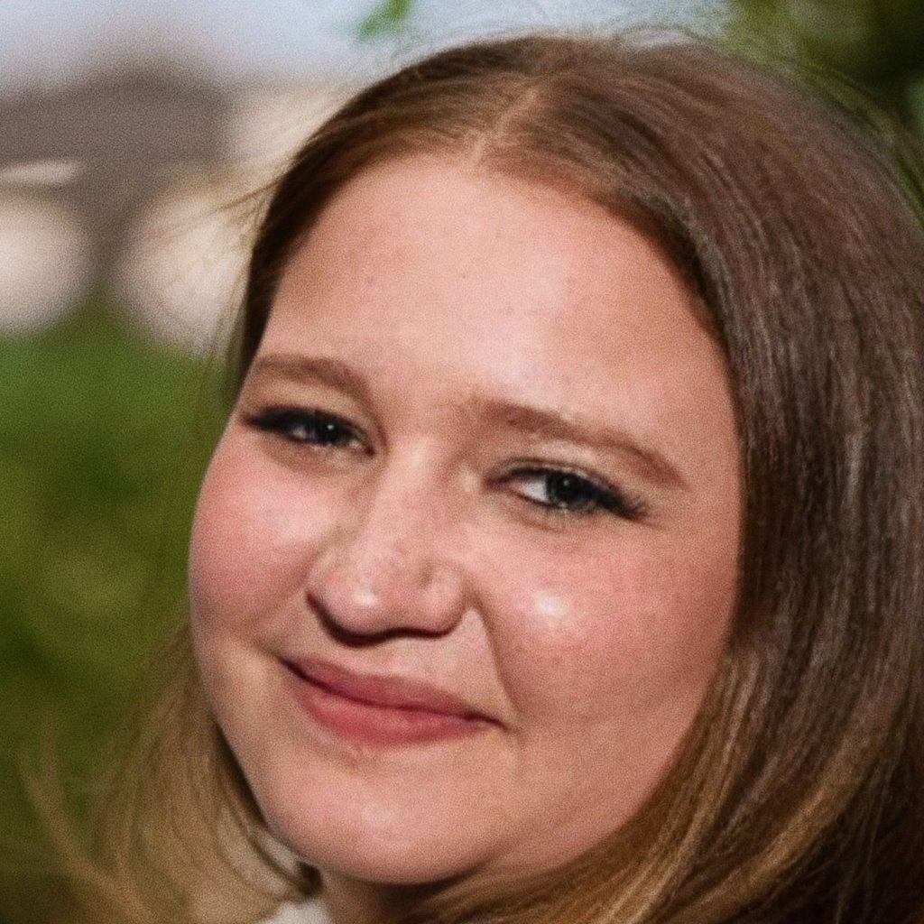 A close up of a woman 's face with a smile on her face.