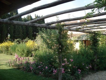 giardino fiorito con copertura di tronchi di legno