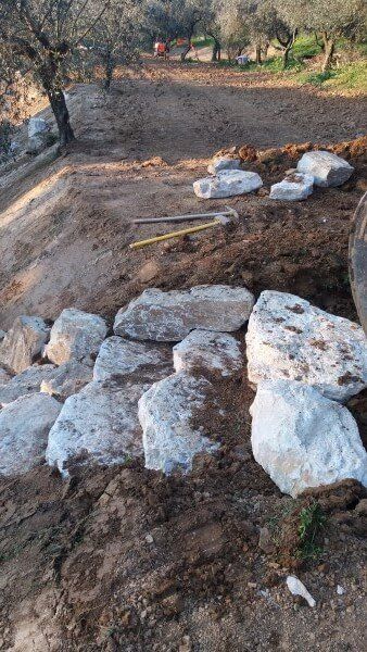 Un mucchio di rocce in cima a un campo sterrato.