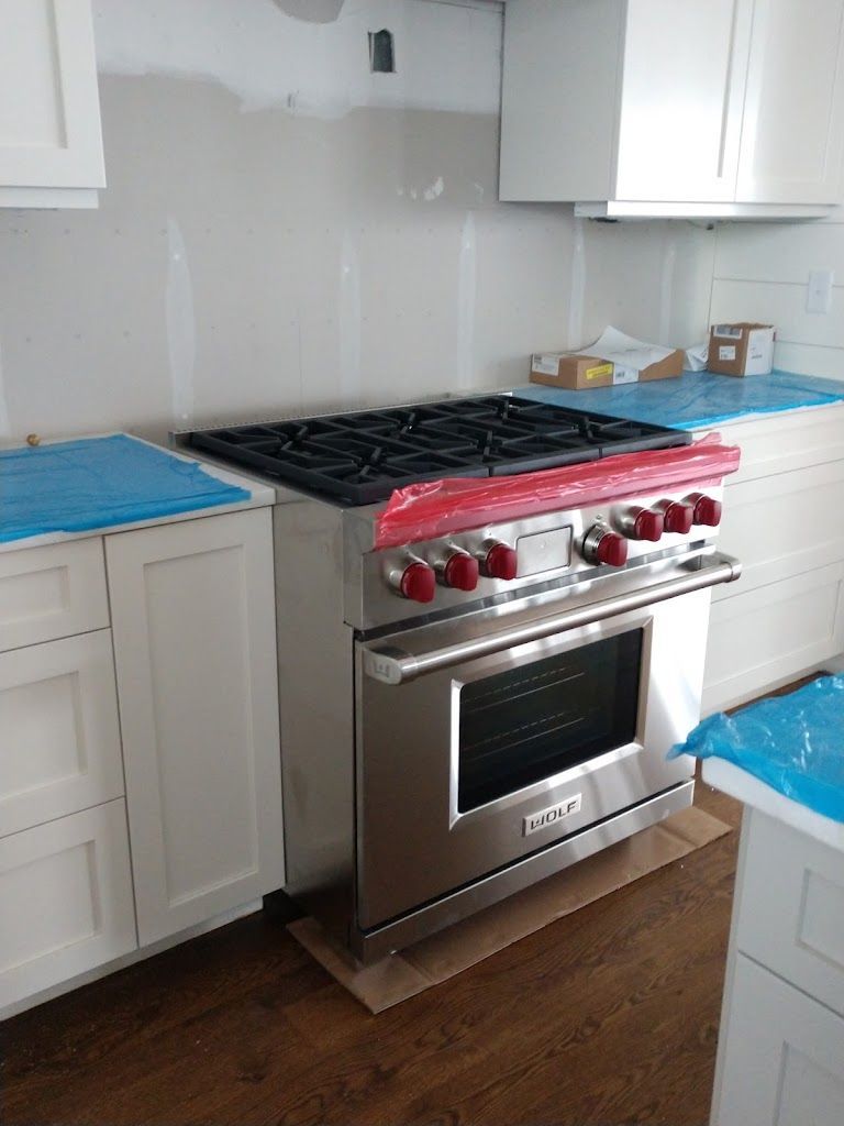 A wolf stove is sitting in a kitchen under construction