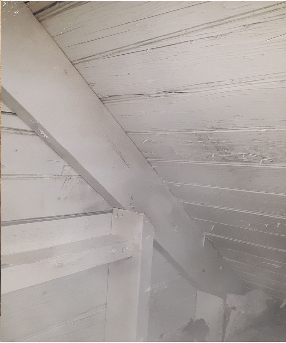 A close up of a white wooden ceiling in an attic.